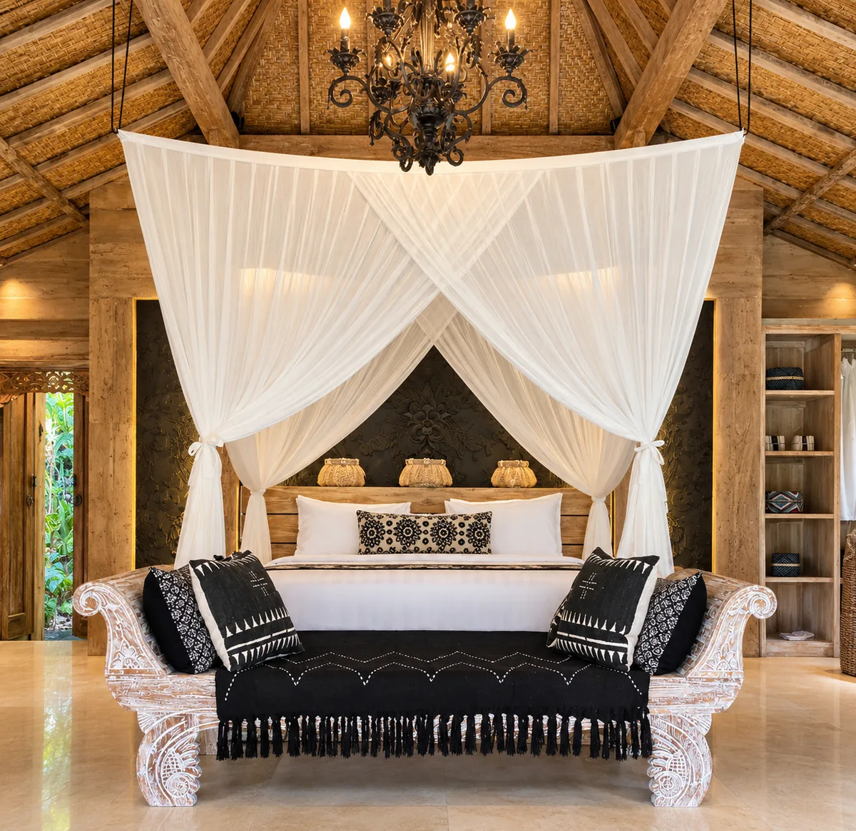 White-draped canopy bed and black upholstered bench beneath a high thatched ceiling and chandelier