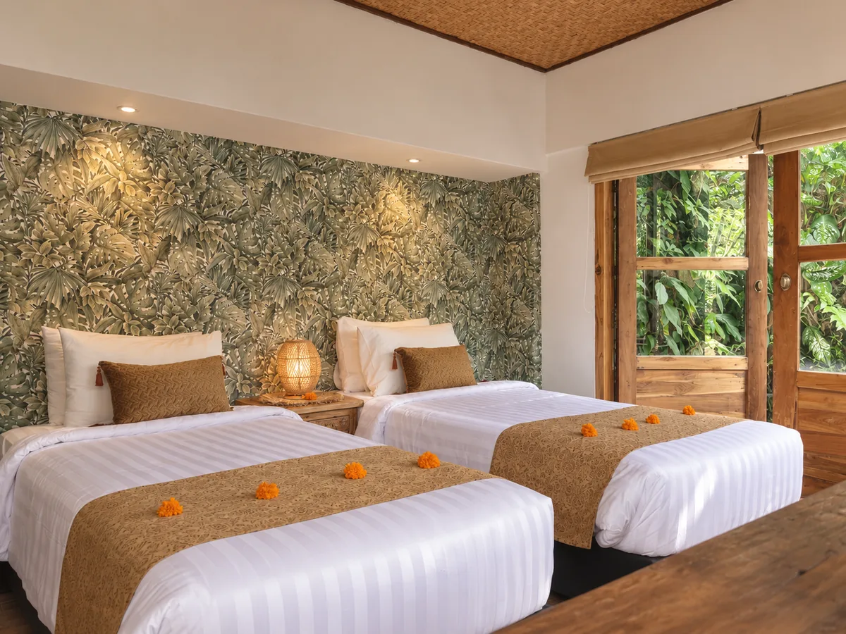 Two single beds with neutral runners beside timber-framed windows and a patterned feature wall