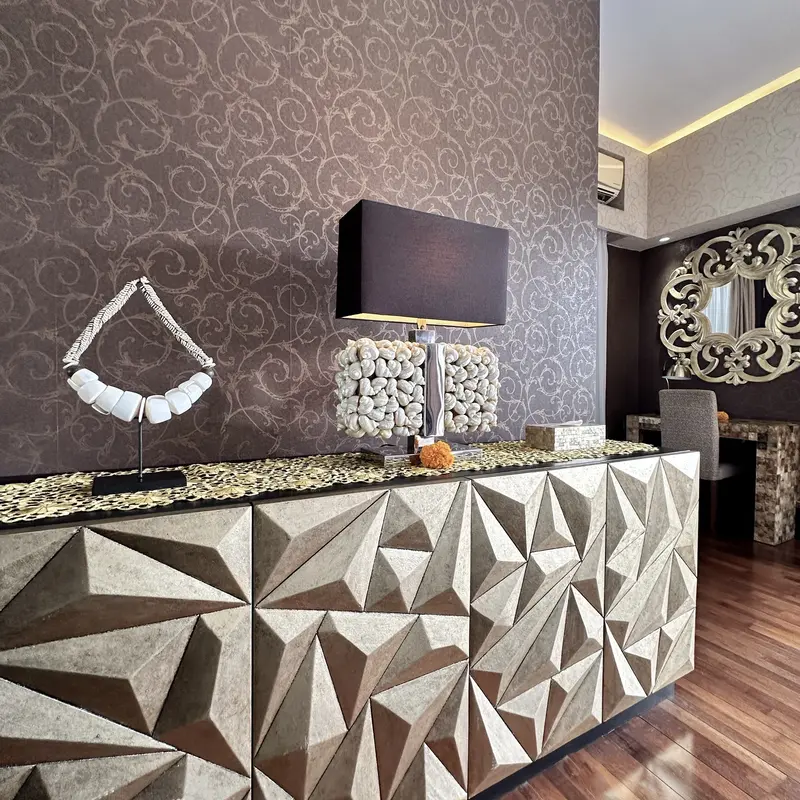 Faceted timber console in Golden Room with a decorative table lamp and gold accents