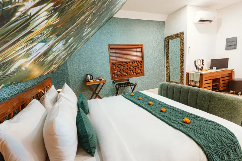 Green Room 1 double bed with green runner, timber headboard, writing table and upholstered bench