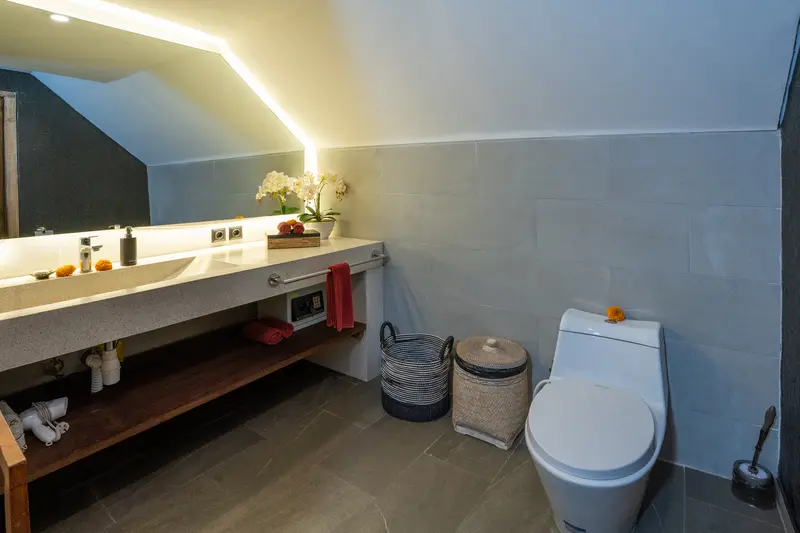 Green Room 2 bathroom showing one long washbasin, one toilet and warm concealed mirror lighting