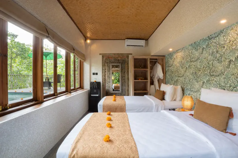 Wide view of Joglo 1st Floor with two single beds, botanical feature wall, timber windows and open wardrobe