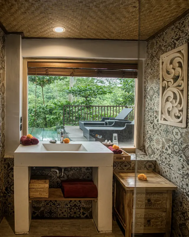 Portrait view of the Joglo 1st Floor washbasin and patterned bathroom looking onto tropical greenery