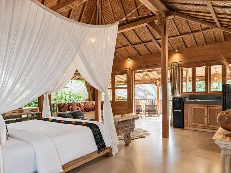 View from the Main Joglo canopy bed towards the kitchenette, sitting area, timber doors and covered balcony