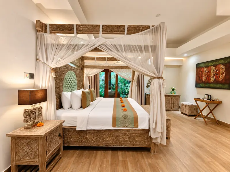 Wide view of Red Room showing the draped canopy bed, carved bedside tables, tropical doors and room furnishings