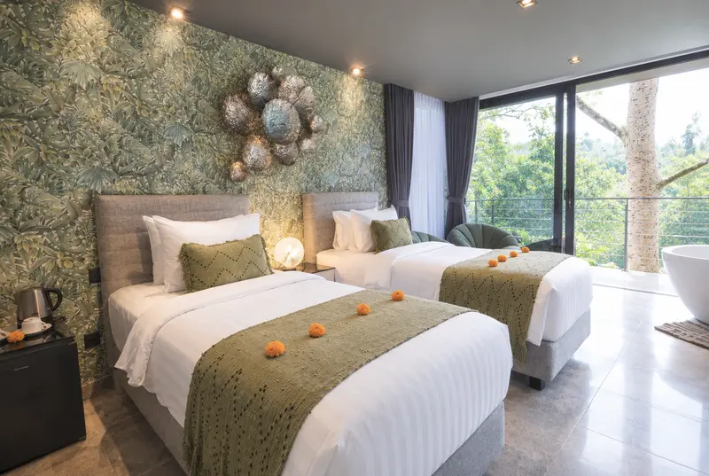 River Villa Room 2 with two single beds, botanical wall covering, olive runners and tropical light