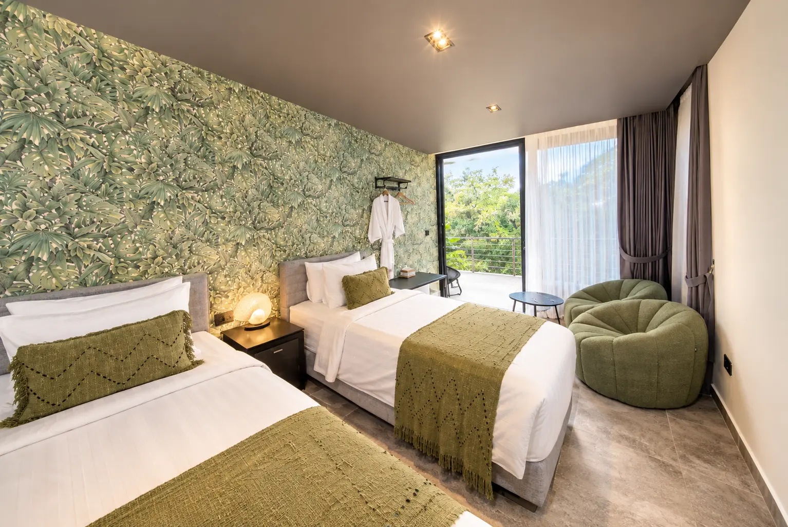 River Villa Room 3 with twin beds, green accents and large glazed doors letting in daylight