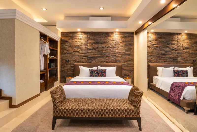 Front view of the Studio Room 1 large double bed with plum runner, woven bench and full-height mirror