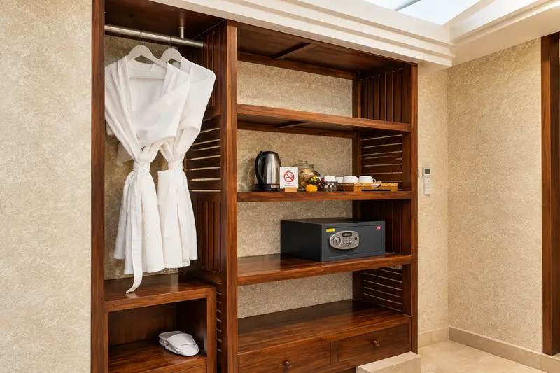 Open timber wardrobe in Studio Room 2 with robes, shelves, safe, minibar, kettle and drink amenities